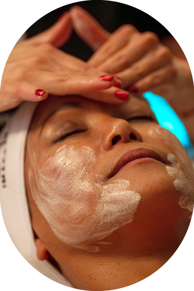 A woman wiping her face after an organic lift facial.